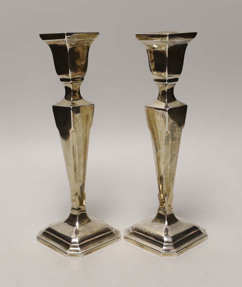 A pair of George V silver mounted candlesticks, London, 1925, height 22.5cm, weighted.